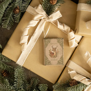The Vintage Book Journal Ornament with Deer Cover is inspired by antique bookshop finds. This ornament is a hardcover journal with a faded cover featuring a deer with antlers and aged paper pages inside that can actually be used for note keeping. It's infused with vintage charm. Makes a sweet gift-topper.