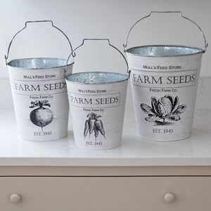 Whether you're gathering flowers from the garden, eggs from the chicken coop, or keeping your home organized, this set of three Vintage Style Farm Buckets will help get the job done. Each galvanized bucket features a vintage inspired seed pack logo and metal handle. Perfect for utensils, flowers and so much more! Set of three