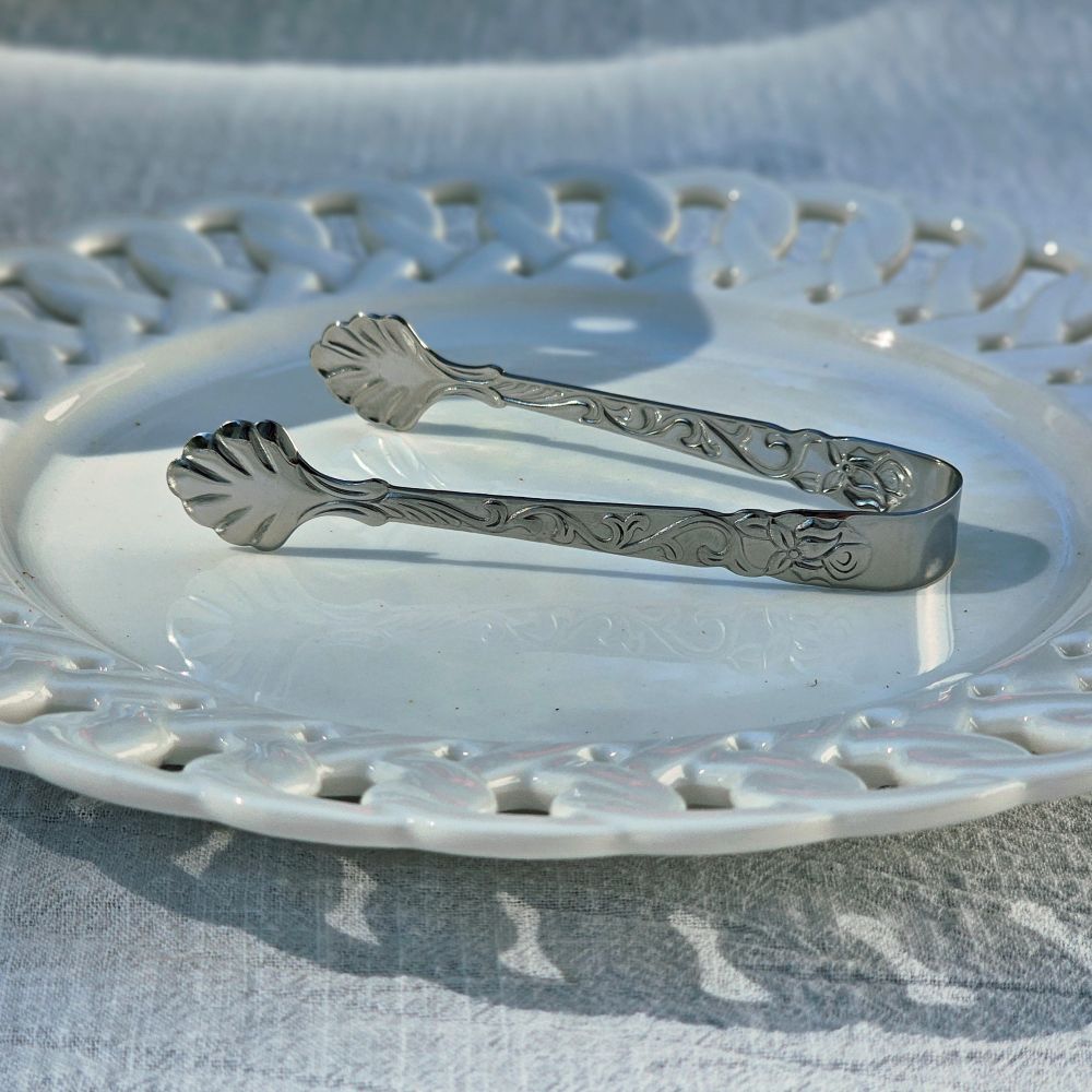 Add a touch of elegance to your entertaining with this Vintage Style Mini Serving Tong. Features a sweet shell design and detailing along the sides, this stainless steel tong is perfect for small items, fruits, such as sugar cubes, olives, ice cubes and more. .66"W x 3.54"L