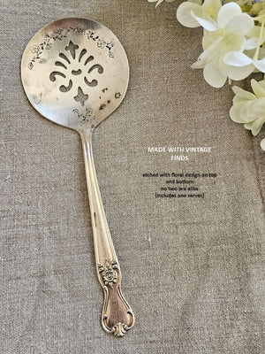 Darling Vintage Tomato Servers are hand-stamped with a floral design along the top and bottom of each server. Made from vintage silver plate servers, each item will be unique. Due to their vintage nature, flatware pieces may show signs of age and gentle use. No two are alike and the face and handle will vary. The servers are all lovingly collected by the artist from flea markets and antique shops and then hand-stamped with care. Includes one tomato server. Each approximately 8"L. Made in the USA.&nbsp;