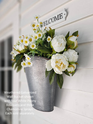 With plenty of cottage style charm, our Weathered Galvanized Wall Bucket offers a rustic touch to any room. It has hearty aged character and is perfect for floral displays. The wall-mounted bucket, has bits of rust, giving it a weathered and worn look. It dresses up any room with vintage farmhouse style. Can also sit on a tabletop. Flowers sold separately. 9″L x 4.8″W x 11.3″H