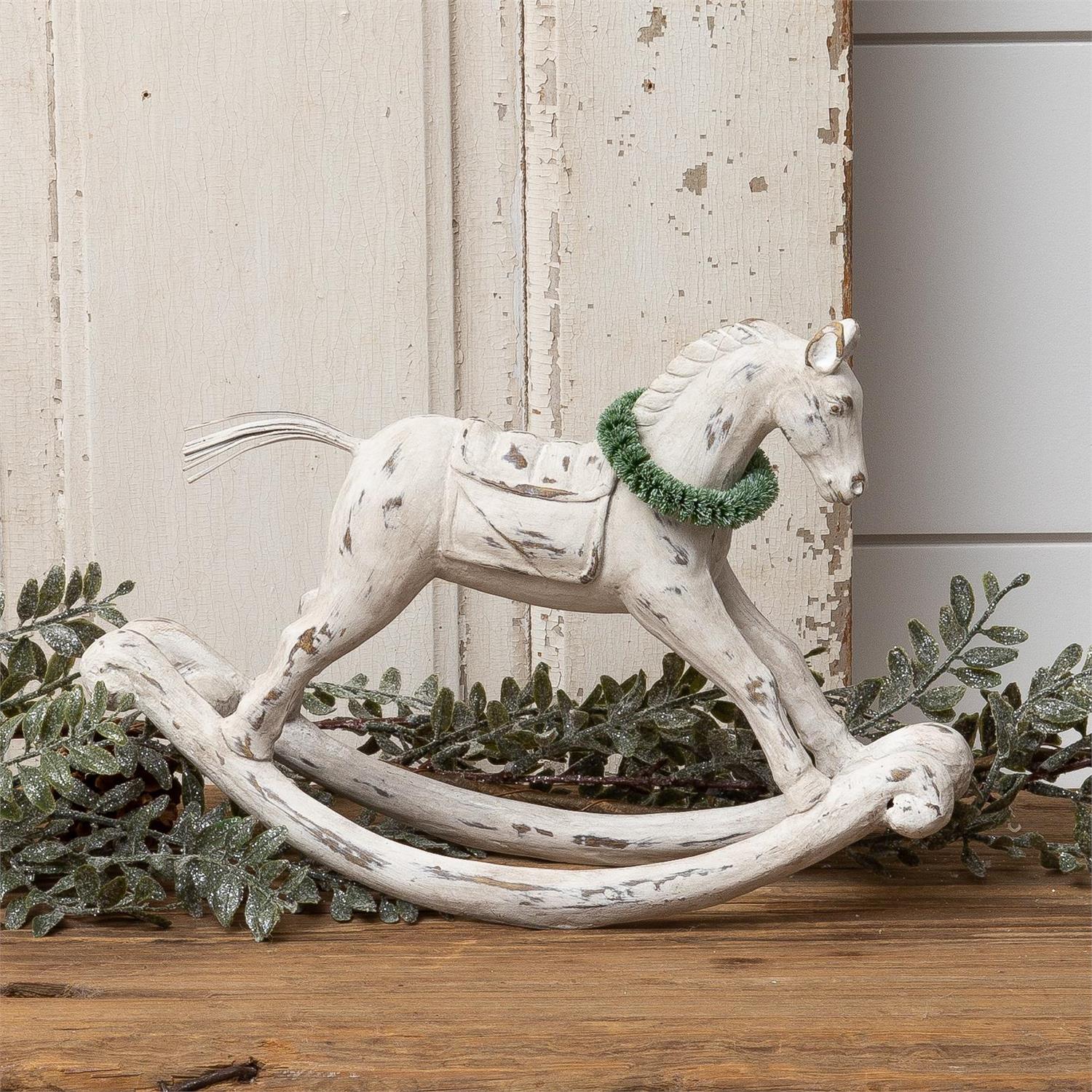 This vintage style Weathered White Rocking Horse with Wreath reproduction features a distressed wood appearance with chippy white paint, giving it a well-worn timeless feel. The sweet, snowy wreath lends a touch of Christmas. Reminiscent of Victorian times, this rocking horse has a shabby chic look. Made of resin