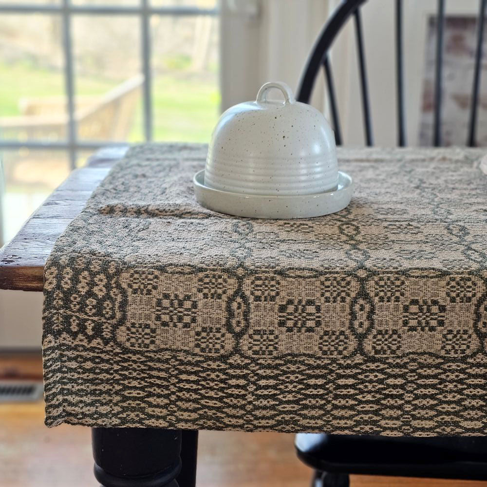 Influenced by vintage Welsh tapestry patterns, the Welsh Inspired Table Square with Green and Flax Design adds instant old-world charm to any room. An ornate geometric pattern adorns the table square, along with a contrasting patterned border. Table squares are perfect for protecting wood tables or even larger tablecloths. They're great for adding a bit of warmth and character to smaller tables. They are made from premium cotton and is machine washable for simple upkeep.