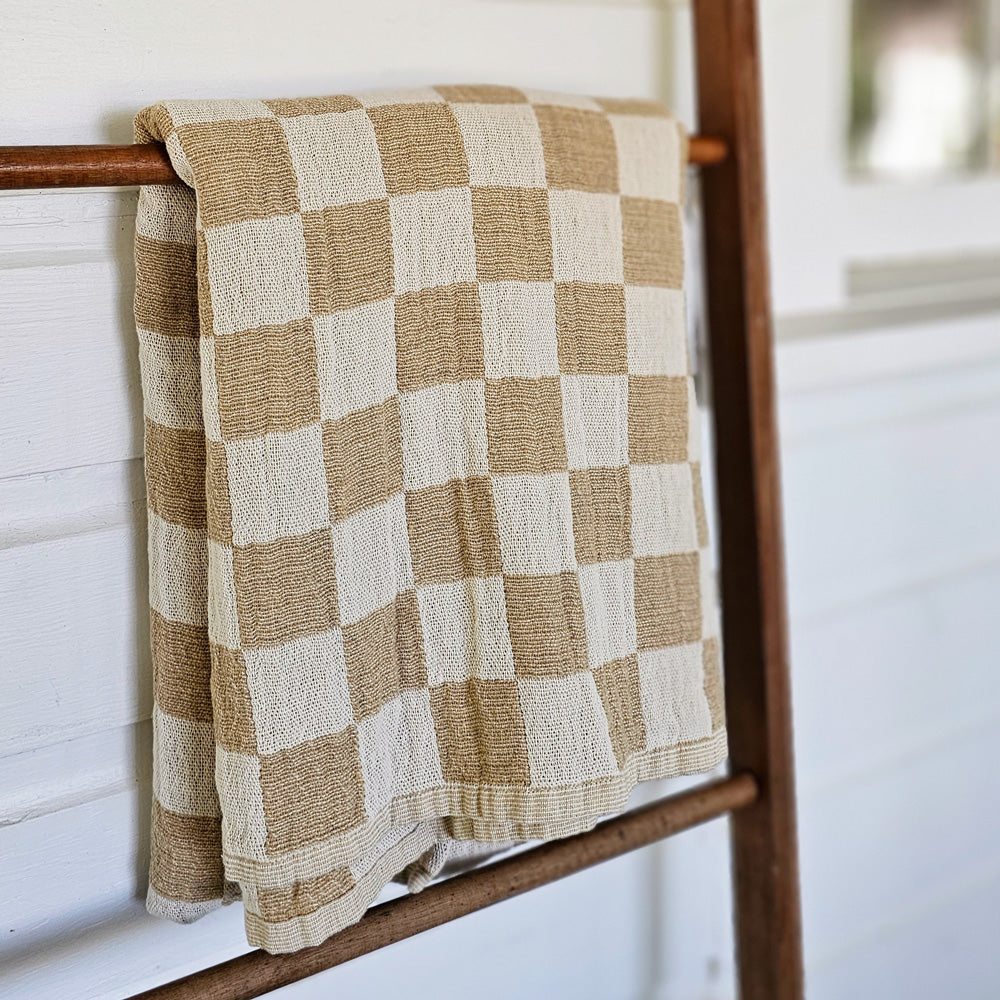 Whether it's on a bed or draped on a chair, you won't be able to resist this throw's amazing texture. The Wheat and Oatmeal Checkered Throw Blanket offers relaxed farmhouse elegance with its rustic gauze-like texture and earthy colors.  The check pattern gives it instant country farmhouse style. It comes with a carry strap, so you can easily take it along to picnics and tailgating adventures. This throw has an environmentally-friendly twist, too!