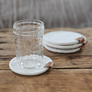 Let these charming White Rope Coaster with Leather Accent,  Set of Four add a modern farmhouse look while protecting surfaces. Sizes may vary within each set. Set of four, approximately 4.2" to 4.75" Diam
