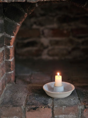 This simple White Glazed Ceramic Taper Candle Bowl, with its quiet elegance and clean design, adds instant ambience to any room. This ceramic taper holder is equal parts modern simplicity and organic imperfection. Features a white glaze finish with a natural, un-glazed bisque exterior.&nbsp; Fits regular size tapers