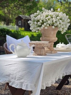 Add dreamy country charm to any occasion with our White Ruffle Prairie Tablecloth. Features a sweet ruffle trim and crisp white cotton. Inspired by vintage home linens, this cotton tablecloth gets prettier with every wash. Create instant cottage style or a dreamy farmhouse tables design for your next event