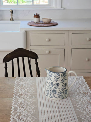 This charming White and Blue Floral Pitcher brings timeless farmhouse elegance to your kitchen or dining table. Crafted with a creamy white base adorned with delicate blue floral motifs, its classic pitcher silhouette evokes the warmth and simplicity of country cottage living. Perfect for serving beverages at gatherings, displaying fresh flowers, or adding a nostalgic touch to your home decor, this piece captures the heart of cottage style