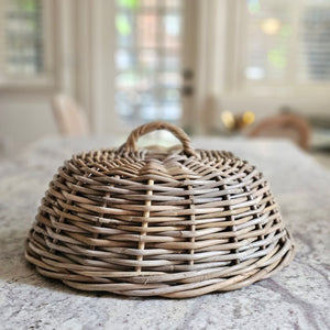 Bring cottage charm and French Country style to your dining table or patio with this Wicker Food Cover Cloche.&nbsp; Also known as a shoo-fly, this Wicker Cloche is perfect for protecting food from flies and other insects. It makes a stunning presentation while keeping food protected from the elements. This natural rattan cloche adds an elegant look to any occasion. 16" Diam x 7.5"H