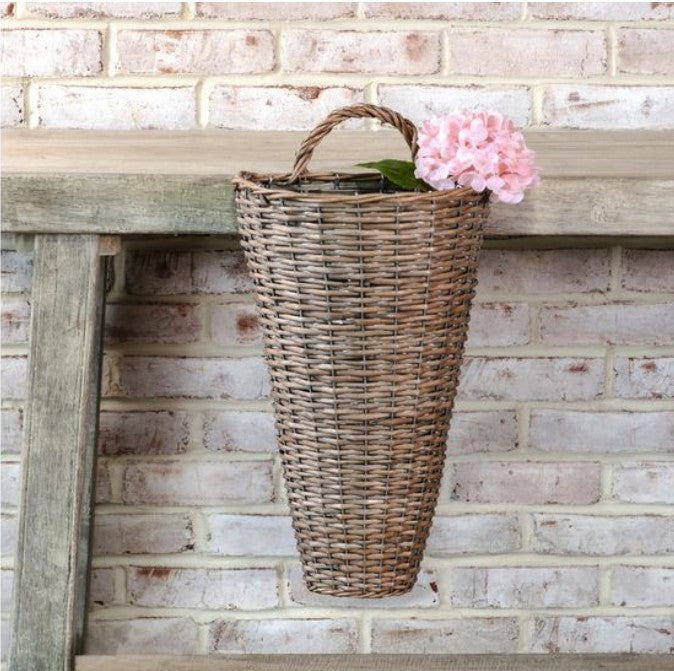 Nothing says country cottage style quite like our hanging Weathered Willow Wall Basket. Perfect for any season. Fill it with your favorite flowers or greenery, and welcome guests with this eye-catching basket on your front door or entryway wall. Includes a handle at the top for hanging. Features a gentle white wash for a vintage French Country weathered look. 11"L x 6.7" deep x 20"H