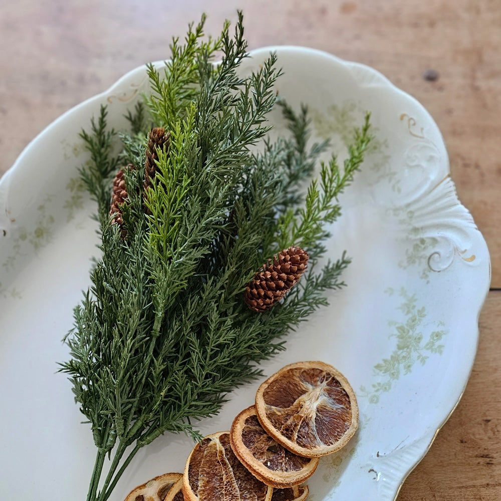 Our Winter Green Pine Pick makes a great filler for baskets and holiday arrangements. The Winter Green Pine Pick brings fresh, earthy greenery to your farmhouse decor. Perfect for adding cabin style or a rustic twist, this realistic greenery with pine cone accents provides a charming decorative accent all year long. 14"H