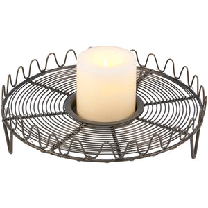 The French Wire Trivet Style Candle Holder merges vintage charm with primitive farmhouse simplicity. Featuring a gray metal wire base with a graceful wave-pattern border, it is inspired by old French wire cooling racks and trivets. 