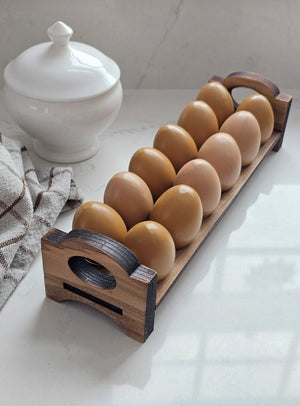 Inspired by antique egg holders, such as ones spotted in the Downton Abbey kitchen, our farmhouse Rustic Wood Stackable Egg Tray will be right at home in your kitchen. It is sold as one tray, and a purchase of two gives you that old-timey stackable look. Makes a great accent for any shelf or countertop. Each rustic wood egg crate holds 12 eggs. Eggs not included. Includes one tray. Purchase two or more for stacking. Made in the USA. 12"L x 3"W x 3.5"H
