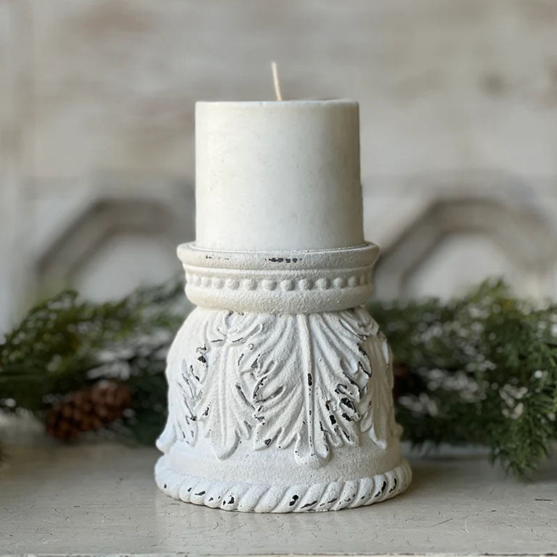 The Ancienne Candle Holder features romantic curves and an aged, chippy white paint look that is familiar to today’s vintage cottage style. This resin pillar candle holder has an ornate carved leaf design and detailing around the base. The Ancienne is perfect for adding a bit of shabby chic flair to any tabletop or bedside table. Candle not included. 4.85"Diam x 4.5"H