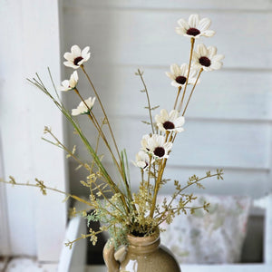 Farmhouse cottage style is made easy with our Faded Meadow Flower Spray. This faux flower spray features tea stained creamy beige fabric petals with dark burgundy pistil centers for a realistic touch. Faded tan-green leaves on a green stem complete this floral. The stem is long, slender, and flexible and is easily shaped for a desired look. 