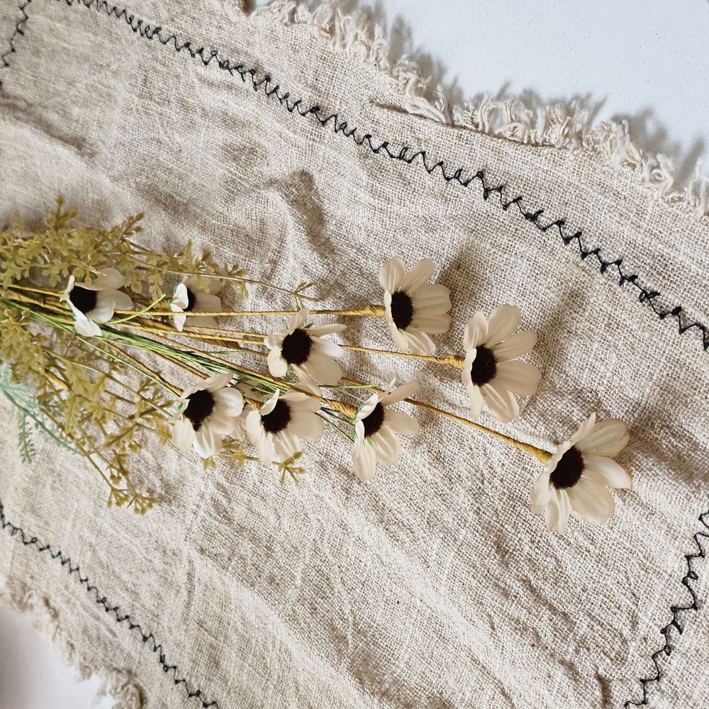 Farmhouse cottage style is made easy with our Faded Meadow Flower Spray. This faux flower spray features tea stained creamy beige fabric petals with dark burgundy pistil centers for a realistic touch. Faded tan-green leaves on a green stem complete this floral. The stem is long, slender, and flexible and is easily shaped for a desired look. 