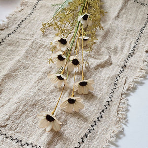 Farmhouse cottage style is made easy with our Faded Meadow Flower Spray. This faux flower spray features tea stained creamy beige fabric petals with dark burgundy pistil centers for a realistic touch. Faded tan-green leaves on a green stem complete this floral. The stem is long, slender, and flexible and is easily shaped for a desired look. 
