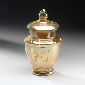 Add a magical touch to any space with our Iridescent Gold Glass Canister, a stunning decorative piece that brings vintage elegance and timeless charm to your home. The vintage-style mirrored glass finish catches and reflects light beautifully, creating an enchanting shimmer that transforms throughout the day. Etched with an intricate flower design on the front, this canister showcases thoughtful craftsmanship and old-world artistry. 