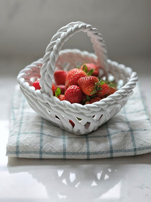 Bring cottage charm to any room with this elegant white woven porcelain basket. Crafted with a delicate lattice pattern, it captures the warmth of traditional cottage style. 