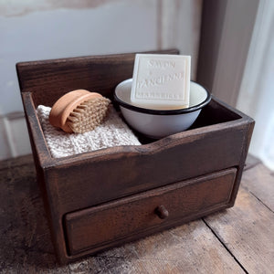Our Wood Counter Cabinet with Drawer is a versatile piece for farmhouse organization. Use on the kitchen counter to create a mini coffee bar, storing k-cups while keeping sugar and other essentials on the top tray. Add to a vintage farmhouse bath to stash away soaps. It makes a great storage box for craft or office supplies, jewelry and more. This sturdy wood cabinet features a tray on top and one drawer. It has a distressed, aged wood finish.