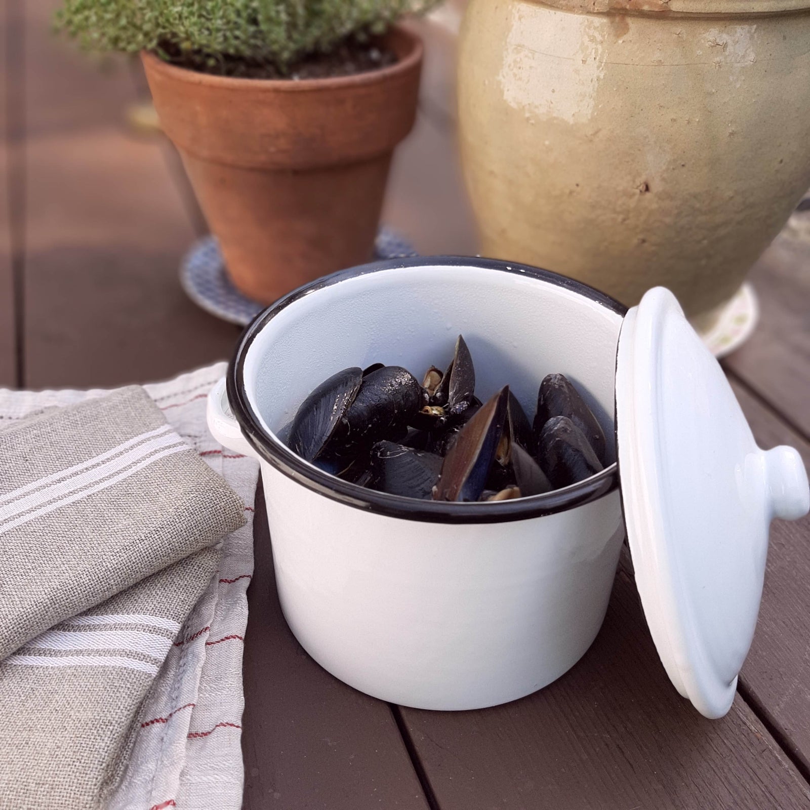 Serve up instant farmhouse charm with this small White Enamel Stock Pot. The white enamel pot, with black rim, adds vintage kitchen style easily. The small pot with lid makes it a snap to keep food warm while entertaining in style.  Item is food, oven and dishwasher safe. Measures 5" high (6.5"H with Lid) by 7" in diameter. Do not microwave.