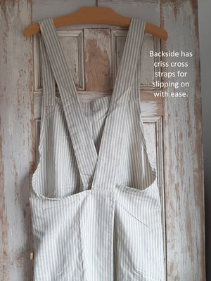 Whether you are crafting or cooking, the Farm Kitchen Smock Apron is perfect for anytime you need coverup. Easily slips over your head so no tying needed. The straps criss cross in back, which is open, so it slips on with ease. Handy pockets on front, made of sustainable 100% cotton with powder blue stripes. One size fits most.