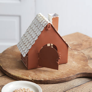 Sugar and spice, everything nice! This Gingerbread Cottage Luminary is ready to spice up any tabletop or shelf. Simply place a candle or fairy lights inside through its latched access door on the back for a magical glow. The gingerbread house can be placed on a table or hung with its keyhole hanger. Candle and light not included. Made of metal. 8¾''W x 5''D x 8½''H