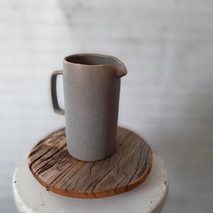 Our Grey Glaze Ceramic Pitcher captures the essence of a quiet foggy morning. A layered glaze of umber and blue gives this ceramic pitcher a cozy mottled texture and misty grey hue. It adds a minimalist touch to your farmhouse with a relaxed beauty that comes from its perfectly imperfect hand-shaped look.  4" Diam x 7"H