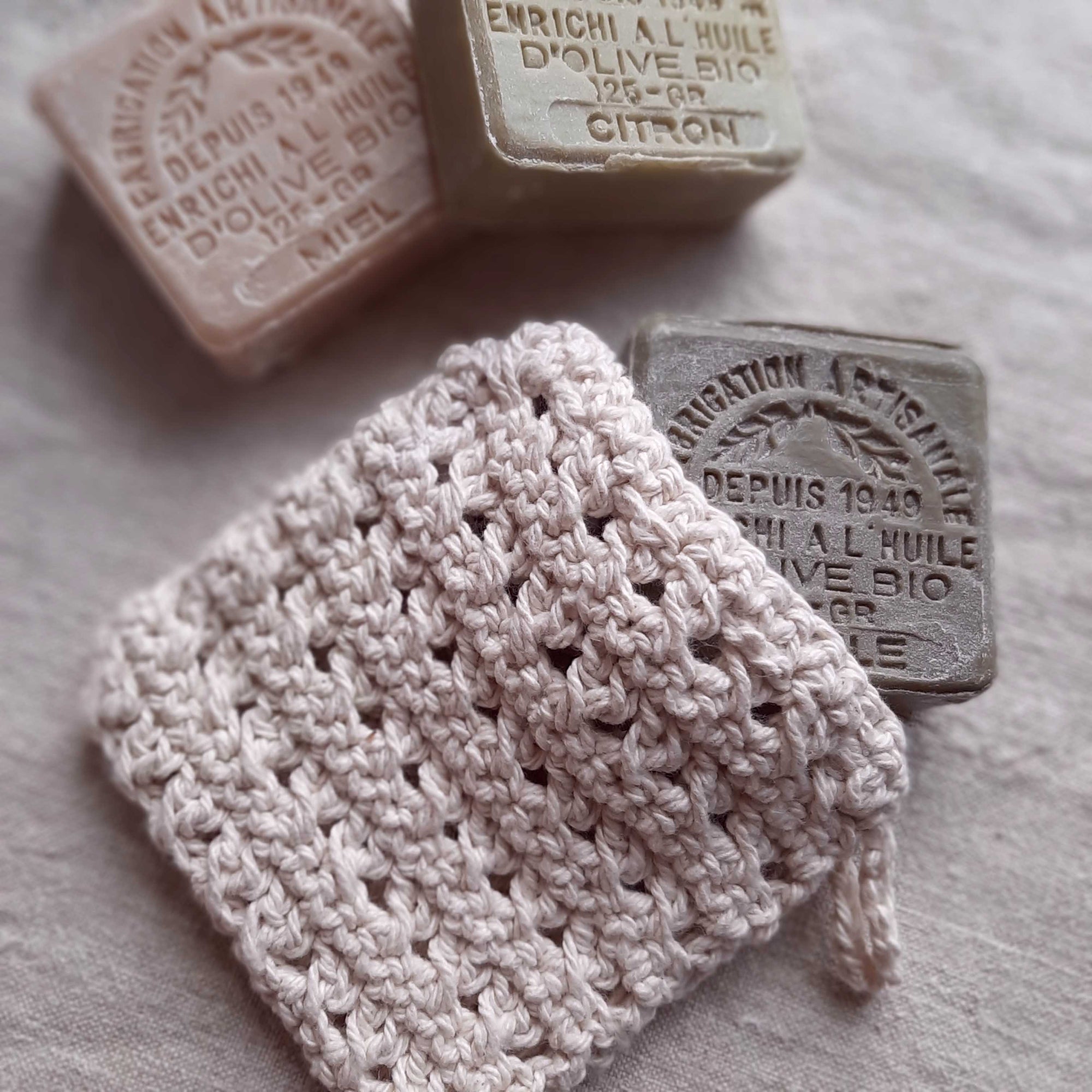 This super soft vintage style Hand-Knit Soap Sock adds a bit luxury to your bathing experience. Handmade of 100% Certified Organic Cotton, this knit soap bag fits a bar soap and creates a rich lather as you wash. Designed for scrubbing without damaging the skin. It promotes circulation and gentle exfoliation. Machine wash/dry. 5"L x 4.5"W x 0.25"H