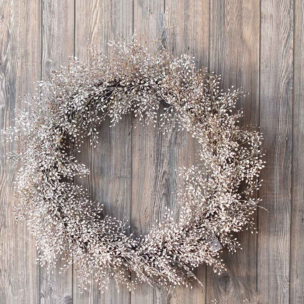 The Ivory Meadow Wreath brings a quiet elegance to any room. This faux foliage wreath features little leaves with various shades of ivory, warm browns and touches of sage peaking through. The frame is made of bundled grapevine.