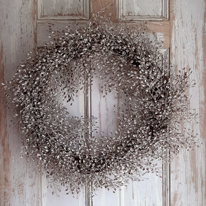 The Ivory Meadow Wreath brings a quiet elegance to any room. This faux foliage wreath features little leaves with various shades of ivory, warm browns and touches of sage peaking through. The frame is made of bundled grapevine. Measure 18-20" in diameter