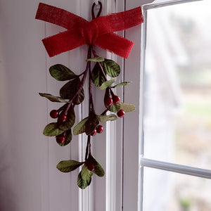 The Mistletoe and Berry Teardrop will surely inspire a kiss or two. This charming faux floral display can hang on a door or wall. Featuring deep red/burgundy berries and vibrant green mistletoe leaves and a red burlap bow. Measures 12" H