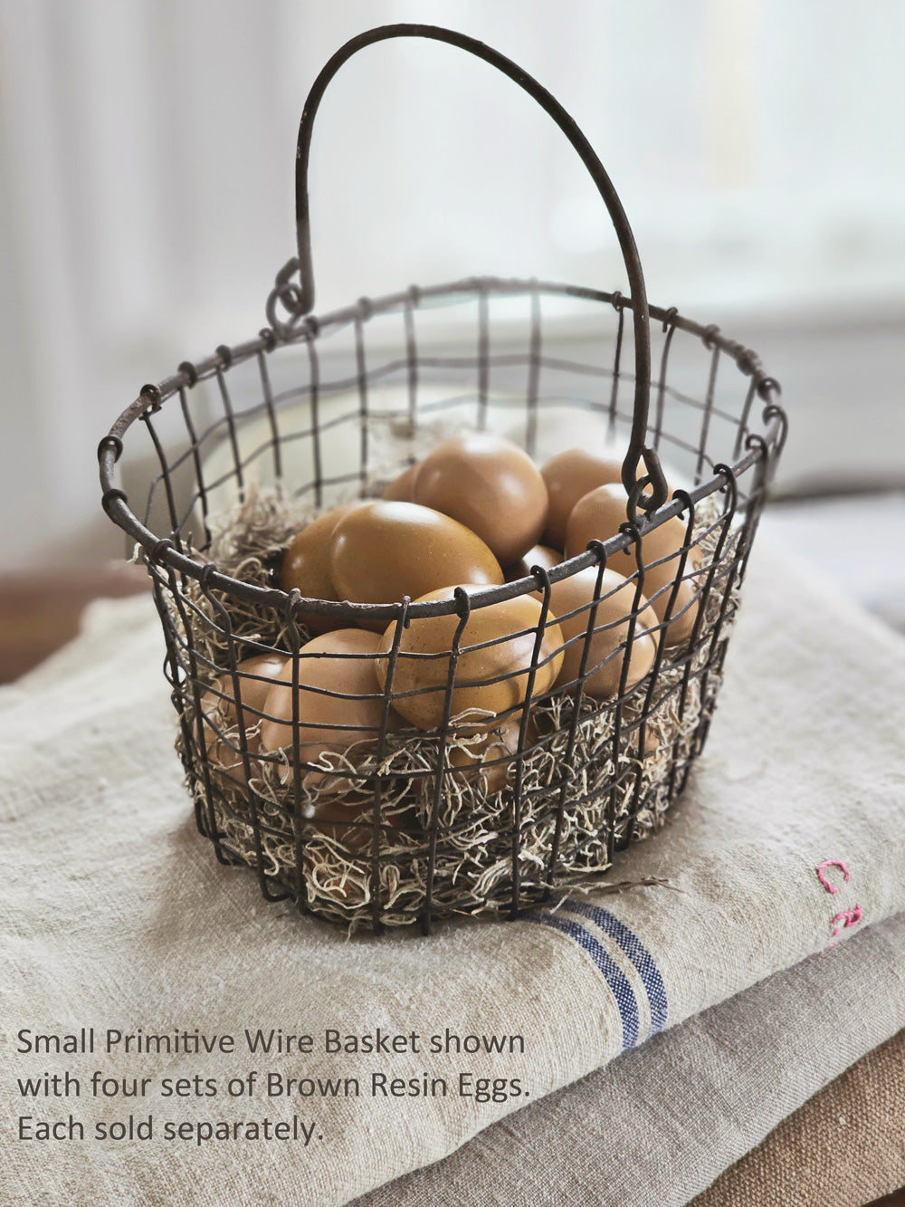 https://farmhousewares.com/cdn/shop/products/Primitive-Wire-Basket-small-with-brown-eggs-TXT_2048x.jpg?v=1681480376