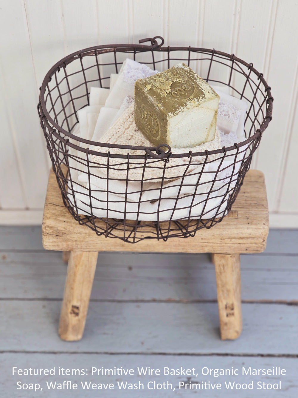 https://farmhousewares.com/cdn/shop/products/Primitive-Wire-Basket-with-wood-stool-and-organic-savon-de-marseille-V-TXT_2048x.jpg?v=1681480376