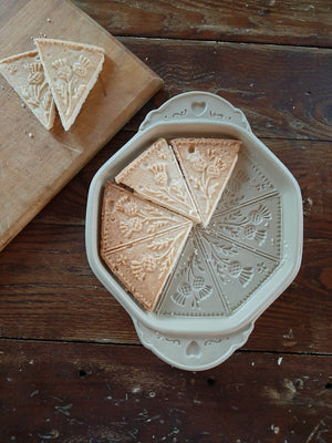 This beautiful Stoneware Shortbread Pan with Thistle Design will have you baking impressive shortbread cookies to amaze guests and give as gifts. Crafted in the USA, this natural stoneware pan lends a beautiful, old-fashioned touch to open shelves when not in use. It creates stunning triangular wedges, which were known as "petticoat tails", embossed with a thistle design.