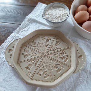 This beautiful Stoneware Shortbread Pan with Thistle Design will have you baking impressive shortbread cookies to amaze guests and give as gifts. Crafted in the USA, this natural stoneware pan lends a beautiful, old-fashioned touch to open shelves when not in use. It creates stunning triangular wedges, which were known as "petticoat tails", embossed with a thistle design.