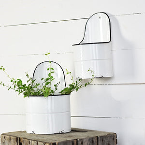 Add instant old-world charm to any room in your farmhouse with these Vintage Enamel Style Wall Buckets. Perfect for displaying plants and flowers or use as a unique storage solution in small spaces. Features aged enamel style finish. Set of two. Small is 6” Diam x 10.5”H, Large is 7” Diam x 11.25”H