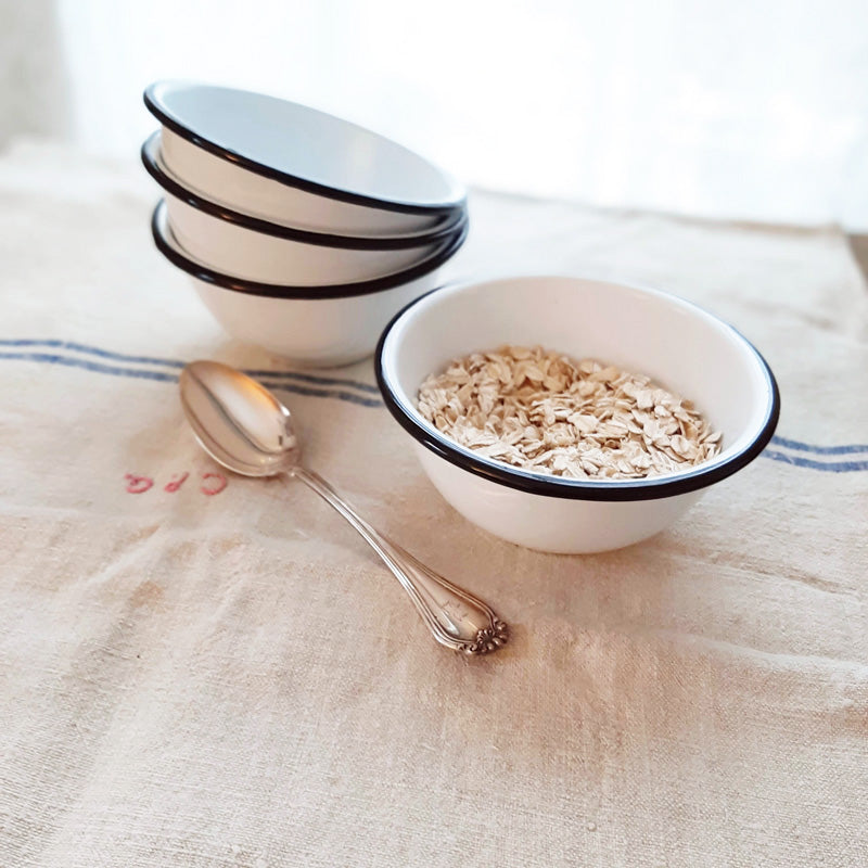 These White Enamel Bowls are perfect for adding vintage farmhouse style to your kitchen. This set of four white enamel bowls includes black rims to emulate those found in antique shops. Their size makes them perfect for morning cereal, for gathering up all your ingredients while you’re cooking, or use them to hold condiments and dipping sauces. Item is food, oven and dishwasher safe. Measures 2¾" high by 5¼" in diameter. 