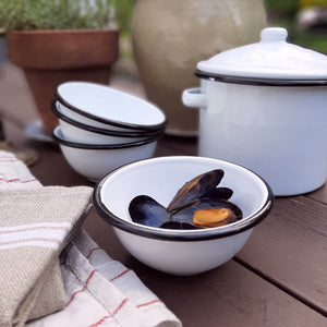 These White Enamel Bowls are perfect for adding vintage farmhouse style to your kitchen. This set of four white enamel bowls includes black rims to emulate those found in antique shops. Their size makes them perfect for morning cereal, for gathering up all your ingredients while you’re cooking, or use them to hold condiments and dipping sauces.  Item is food, oven and dishwasher safe. Set of four.  