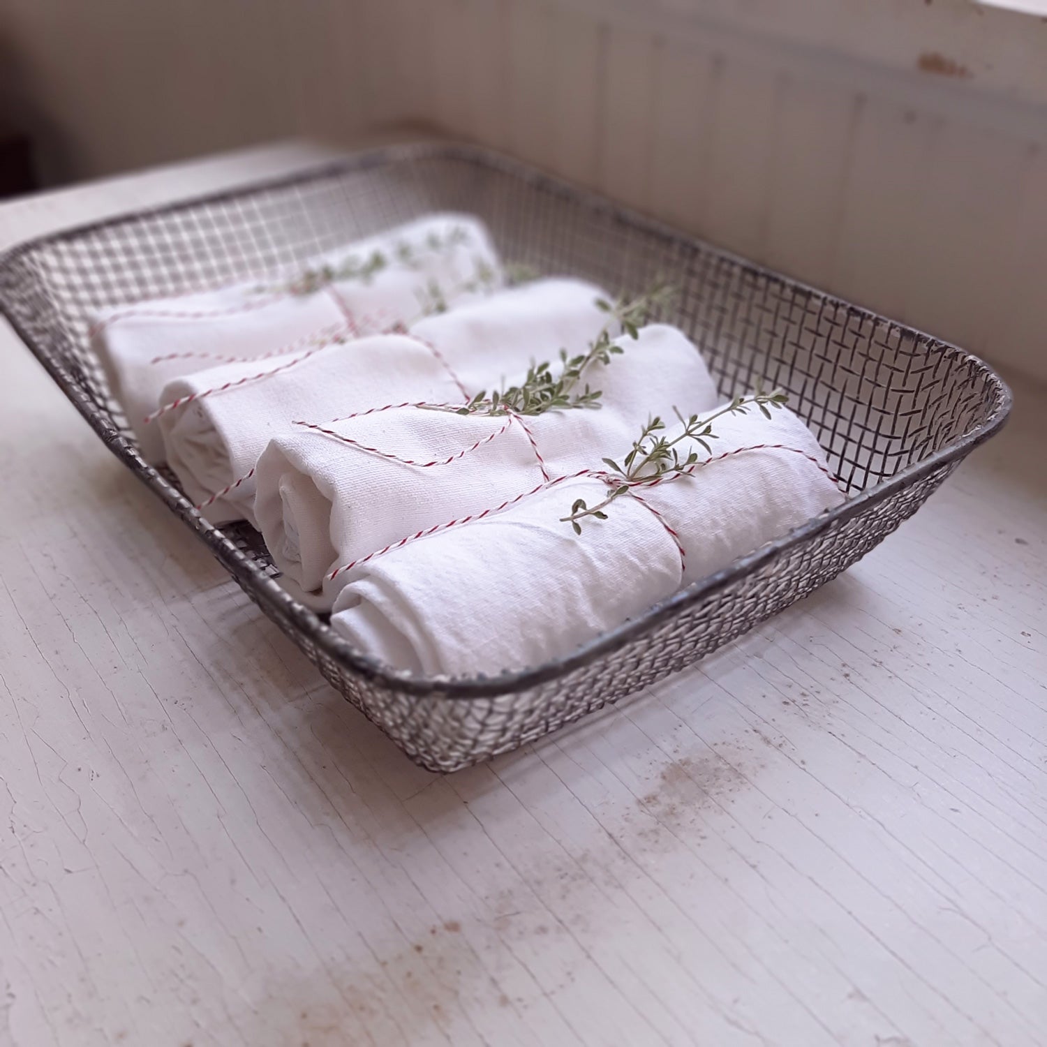 Our Wire Tray Basket offers quintessential vintage farmhouse style. This charming shallow wire basket is perfect for berries and fruit or for mail and more. This antique inspired wire mesh tray basket features a weathered metal finish with hints of chippy white paint.