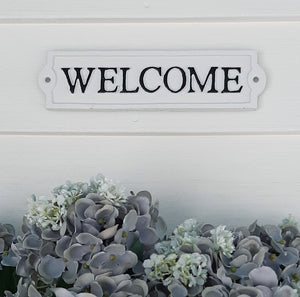 Give your guests a warm welcome with this Vintage Style Welcome Sign. Inspired by vintage enamel signs, this sturdy cast iron sign is white with raised black lettering and trim. (hardware not included.) 8.65”L x 2.15”H